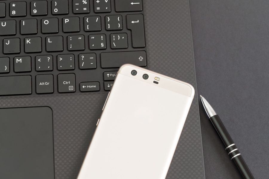 A phone resting on a laptop keyboard
